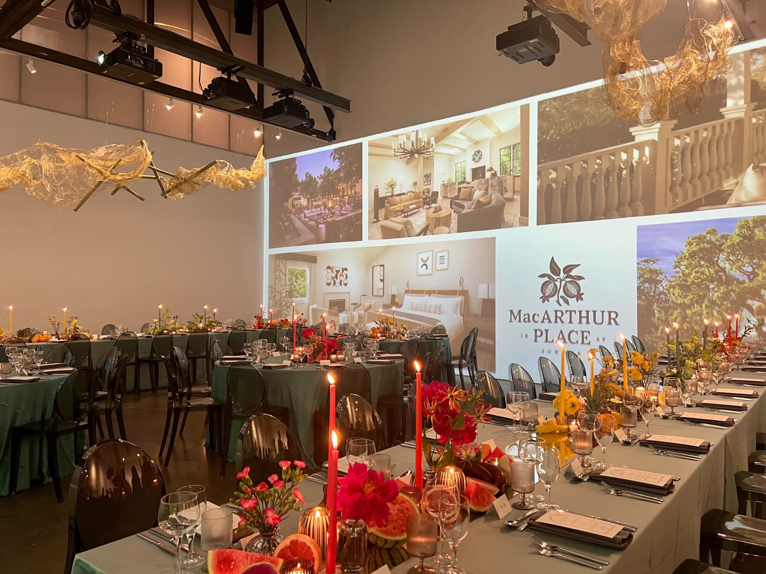 Dinner tables in front of a projected MacArthur Place installation